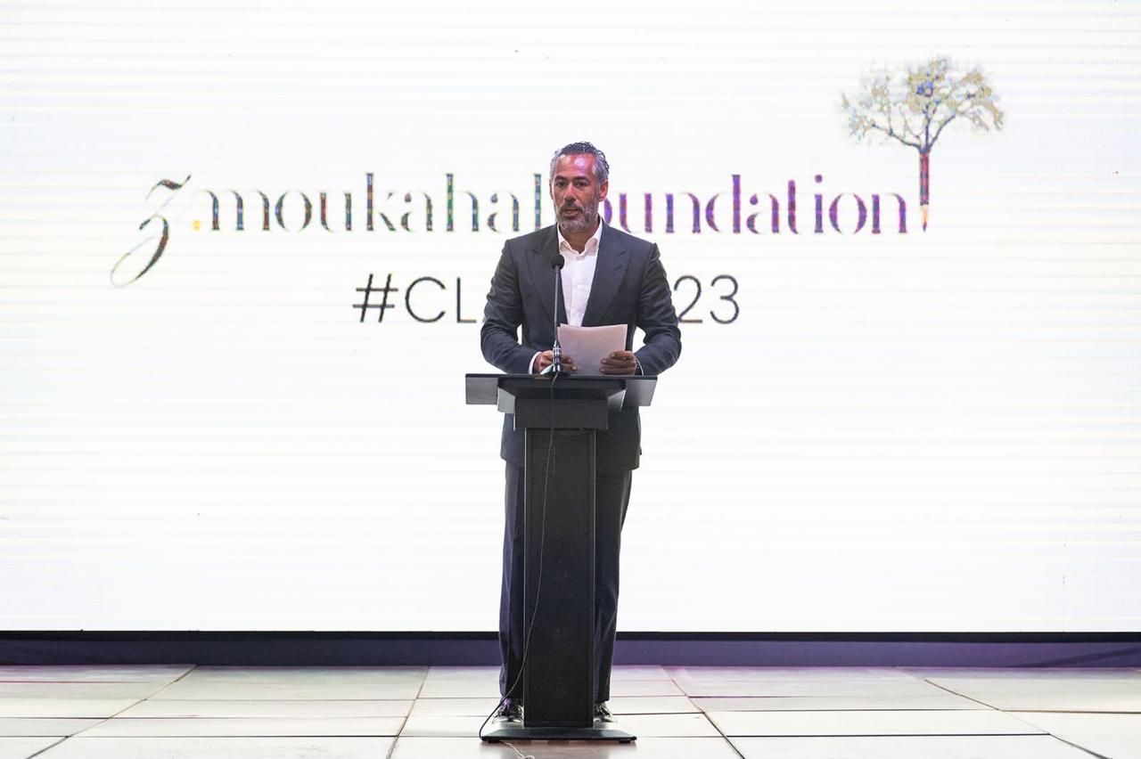 Wissam Moukahal speaking at a lectern. The backdrop behind me reads “z. moukahal foundation”